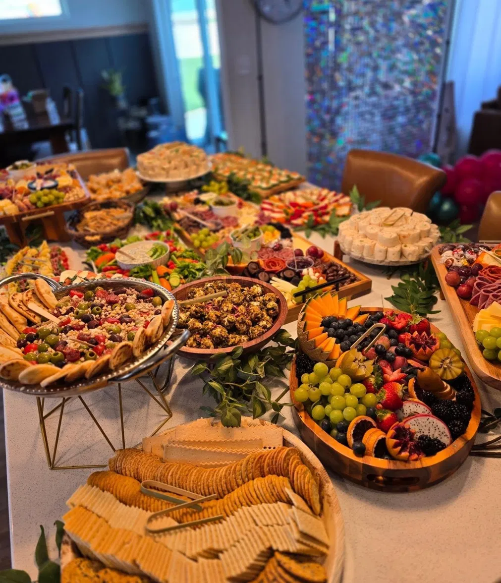 Event spread with crackers, salads, and a fruit board